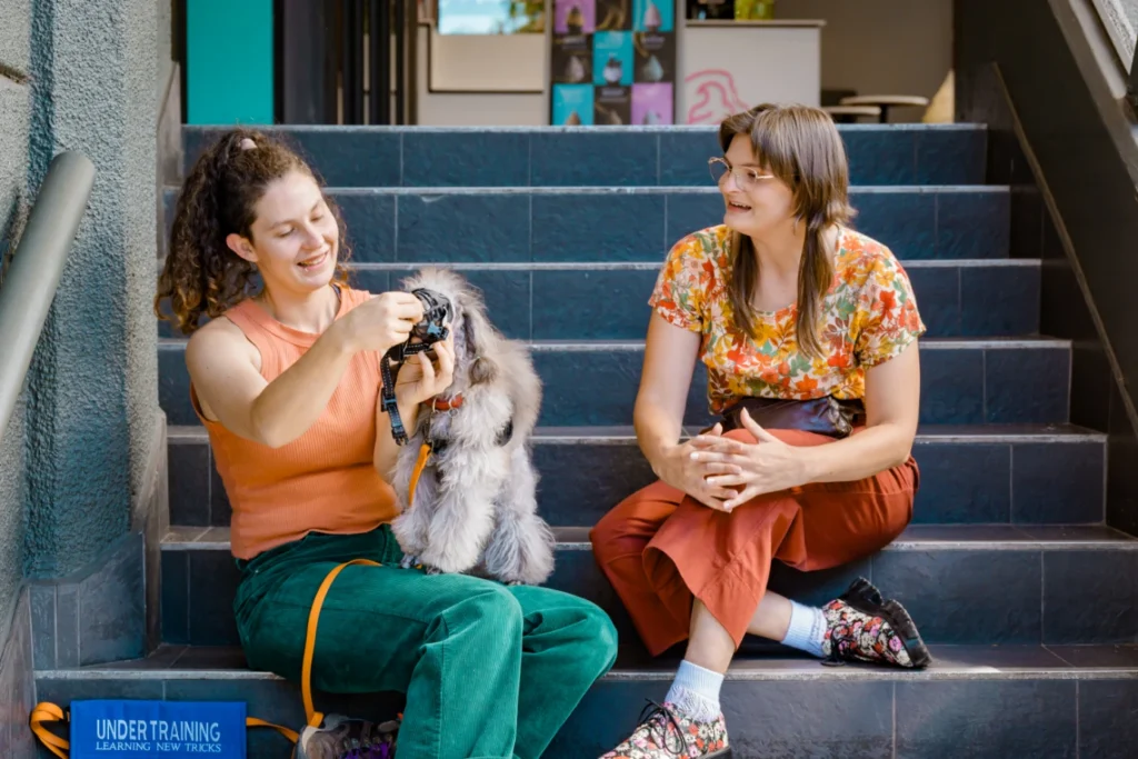Liv of Liv'sBestFriends consults with a client, giving her instructions on how to put a muzzle on her small dog.